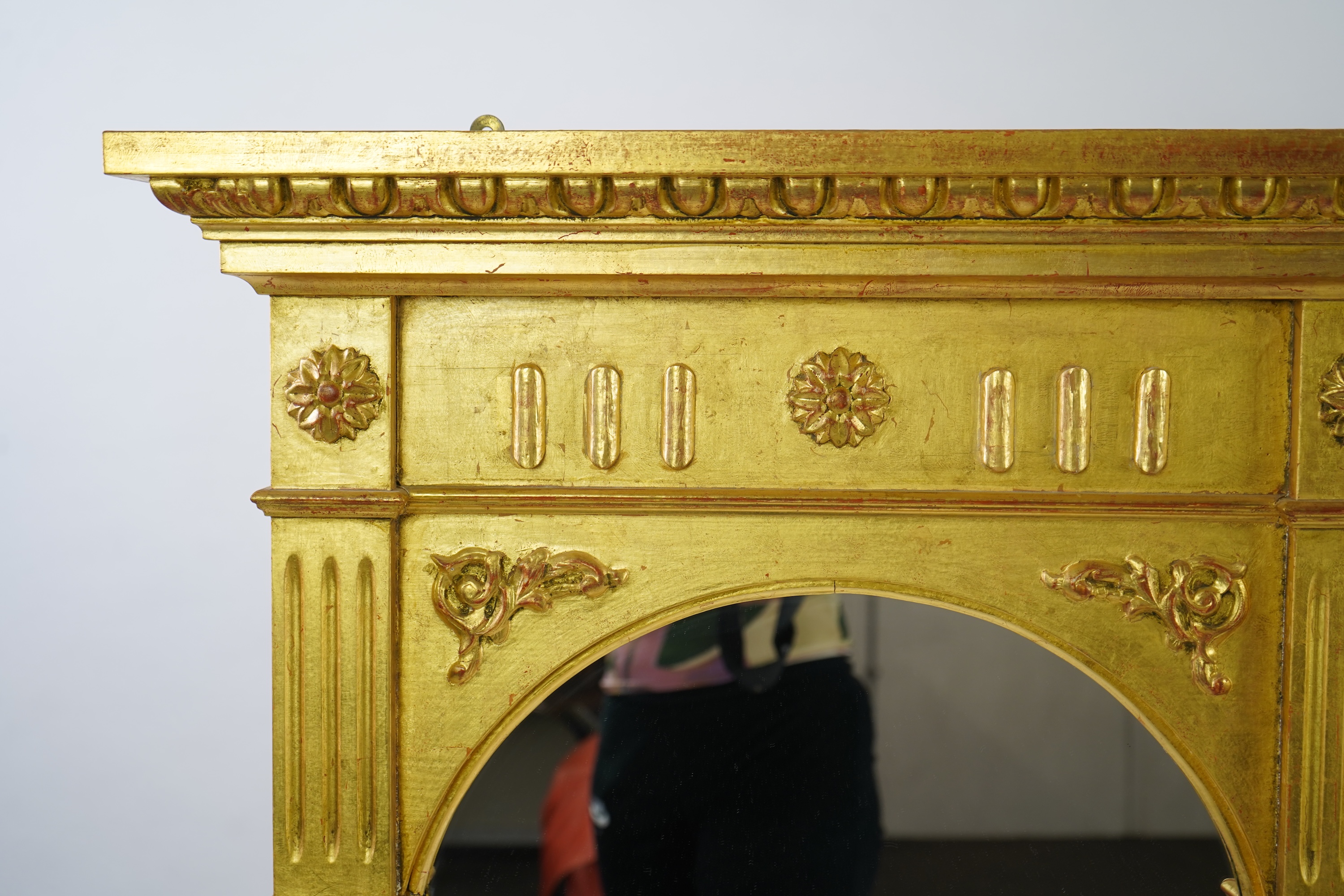 A Victorian style giltwood and composition triple plate overmantel mirror, with foliage scroll torch pediment over a flower head frieze and fluted pillars, 222cm wide,152cm high